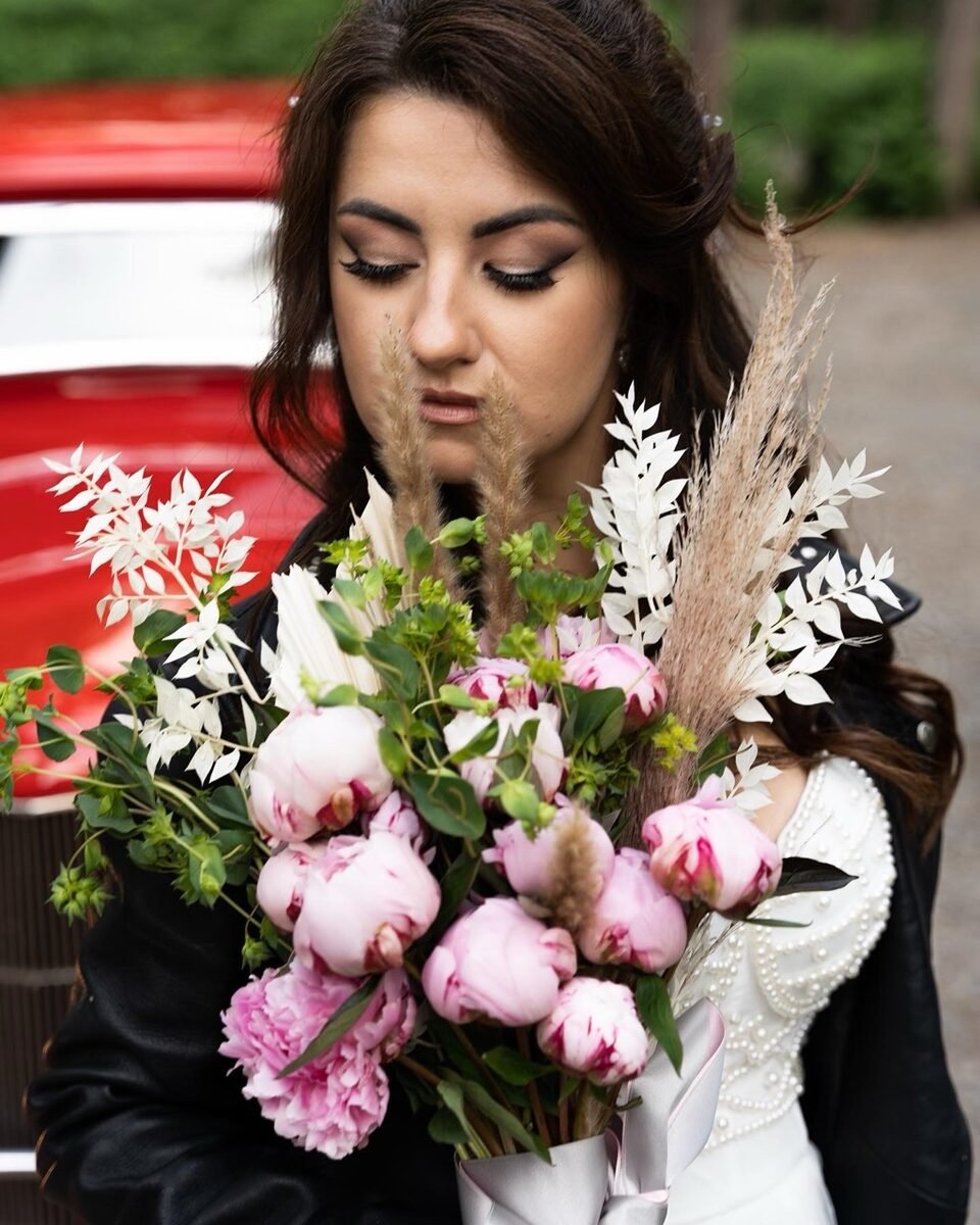 Bride holding a pink peony bouquet wearing soft bridal makeup