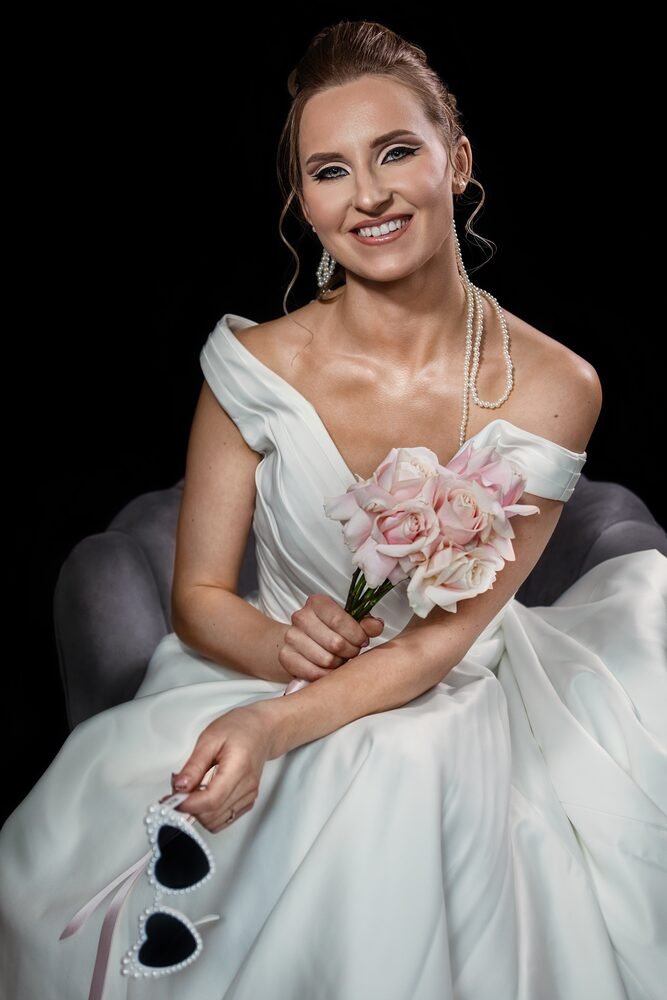 Bride smiling in a white dress with soft bridal makeup