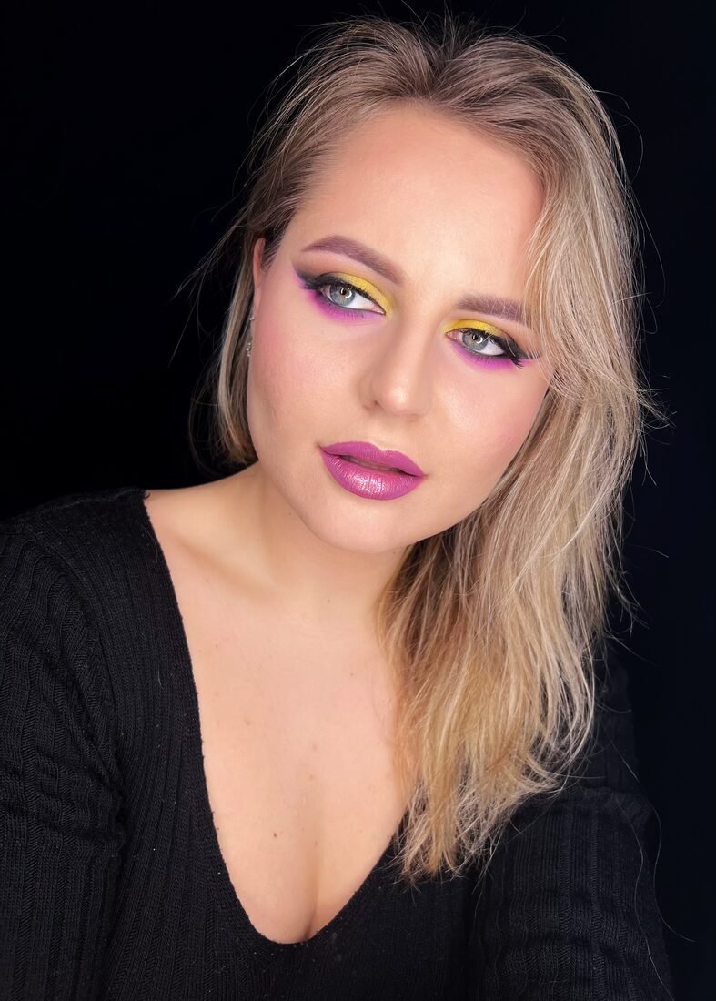 Bright graphic eye makeup in yellow and pink with a clean skin finish