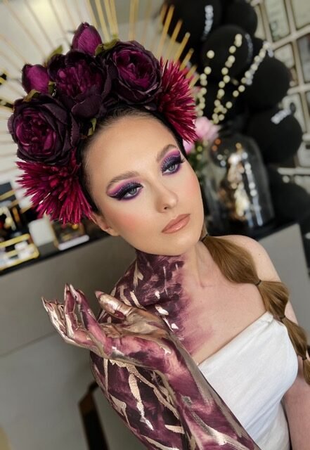 Editorial makeup styled with a deep red floral crown
