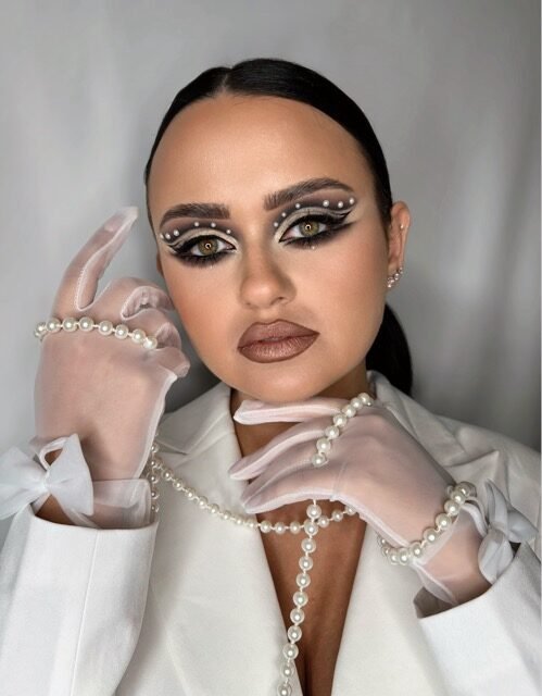 Graphic liner look styled with pearls and sheer gloves