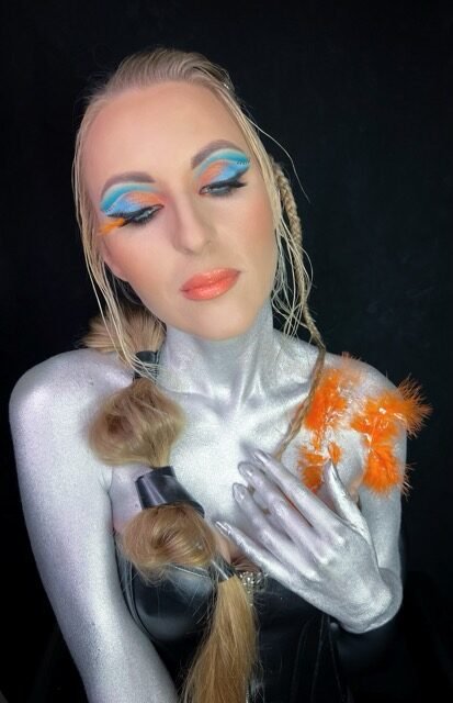 Silver body art and blue graphic eye makeup, competition look