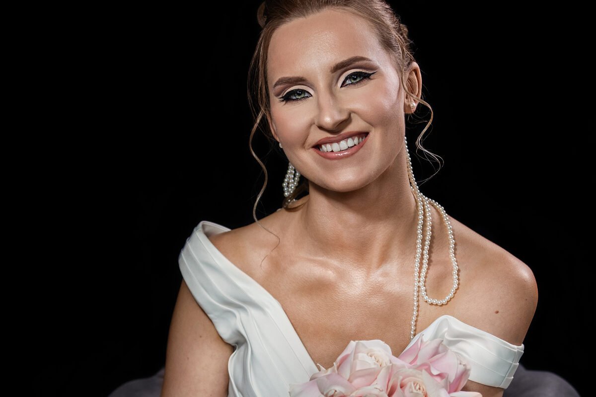 Bride with soft wedding makeup, pearl jewellery and pale pink roses